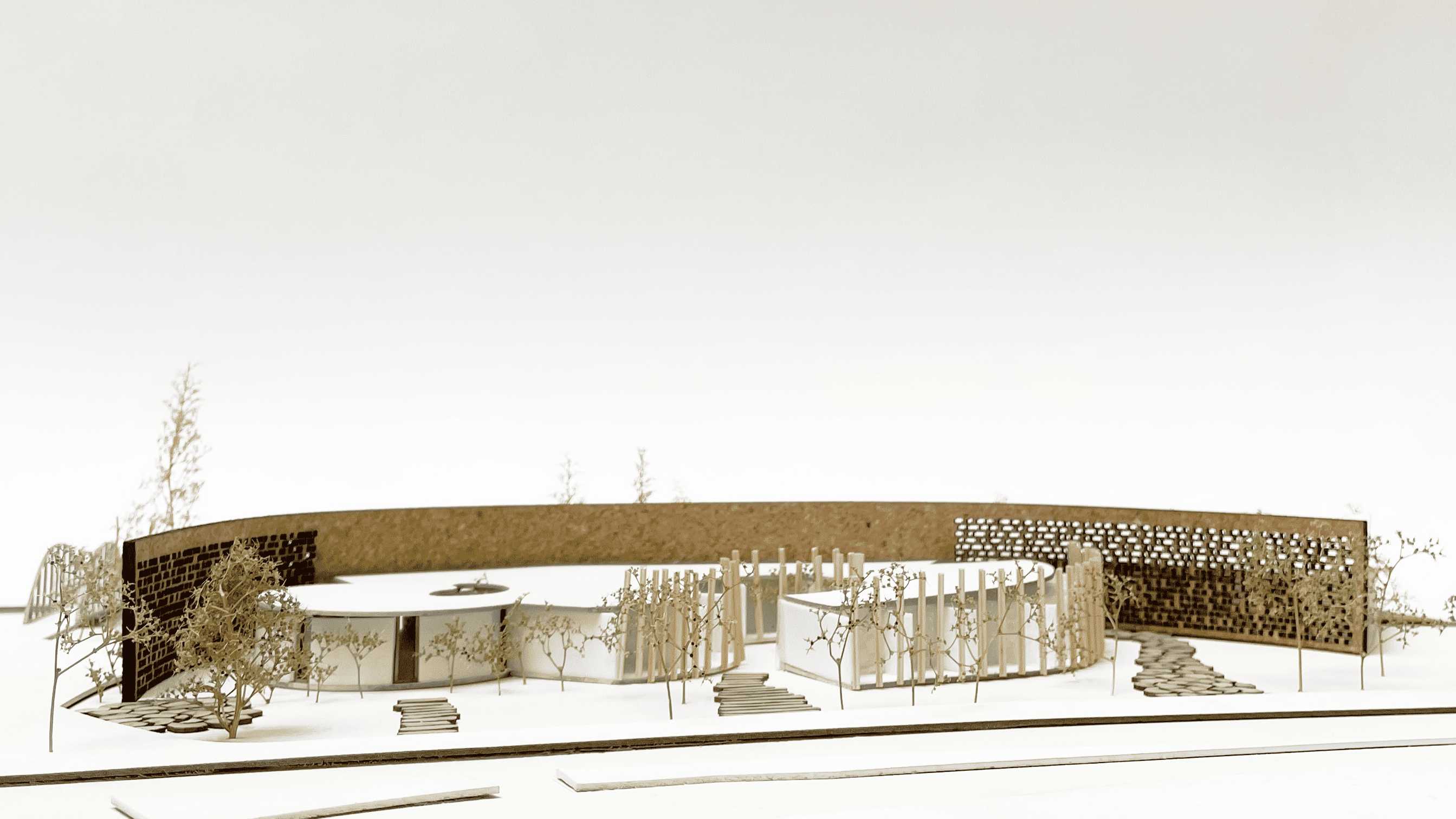 Physical model of Renewal Hub with calming pathways, bamboo screening, and perforated brick wall entrances that create a harmonic balance of privacy and openness for a therapeutic setting.